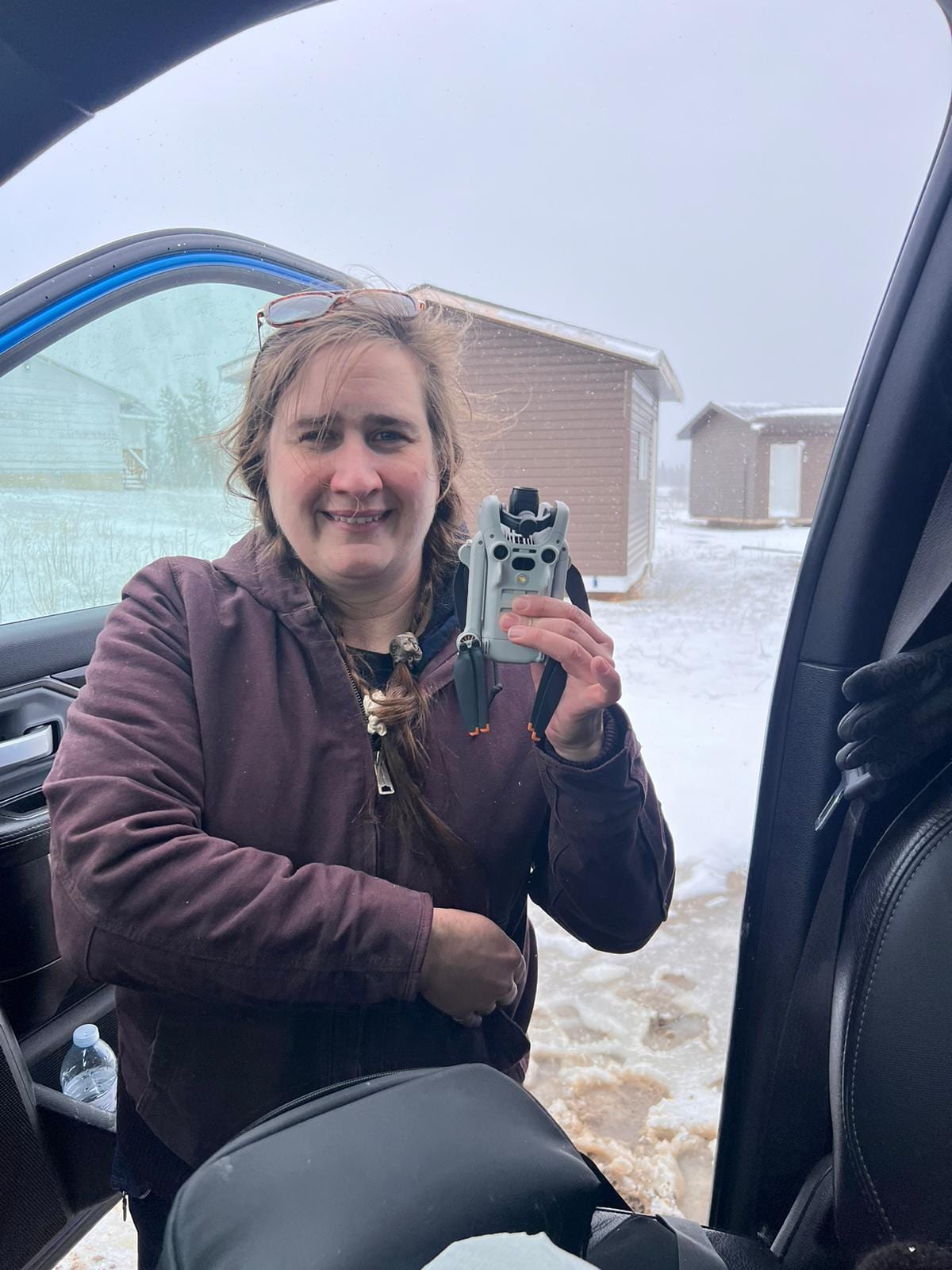 Helen holding a folded drone during winter fieldwork
